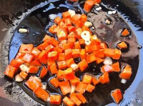 锅中倒入底油加热放入蒜粒爆香再放入胡萝卜炒至断生