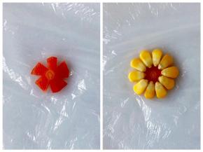 把一片水果胡萝卜片切成小花的形状，周围放上玉米粒，然后放上饭团裹好。