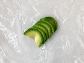 牛油果切成薄片摆好，然后放上饭团裹好。