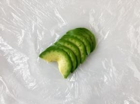 牛油果切成薄片摆好，然后放上饭团裹好。