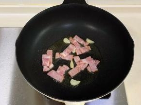 锅中倒入橄榄油，先放入蒜片爆香，加培根炒至微焦，盛出。