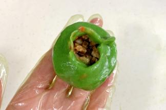 把菠菜面团分成8等份，按扁，舀入1勺内馅，收好口子。