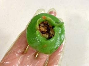 把菠菜面团分成8等份，按扁，舀入1勺内馅，收好口子。