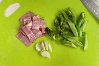 切好培根、蒜片和芦笋。