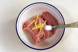 往里脊肉中加2勺料酒和姜丝，腌制10分钟。