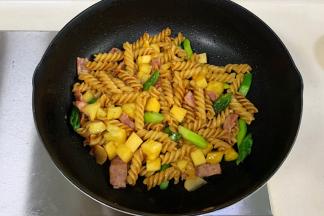 加入菠萝丁、芦笋和培根，翻炒均匀即可。
