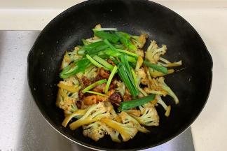 倒入五花肉、蒜苗和长椒翻炒1分钟即可出锅。