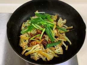 倒入五花肉、蒜苗和长椒翻炒1分钟即可出锅。