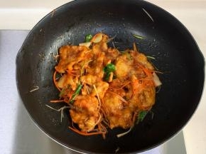 把炸好的肉片入锅，撒入胡萝卜、葱丝和香菜炒匀出锅。