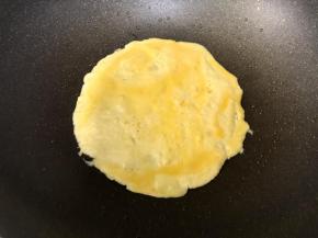 先倒入1/3的蛋液，均匀摊开，煎至7成熟。