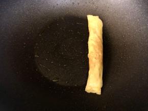 把蛋皮卷起，放在锅的一边；