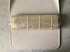 借助寿司席把米饭包裹厚蛋烧卷起。