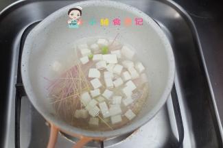 锅里水煮开后放入面条跟豆腐