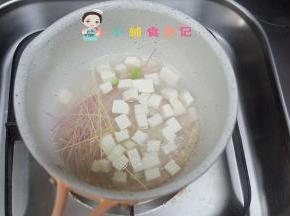 锅里水煮开后放入面条跟豆腐