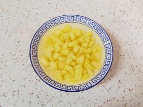 碗里放一点点盐加入纯净水，放入切好的菠萝果肉在淡盐水里面浸泡5分钟左右取出，控一下水分备用。