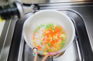 锅里水煮开加入青豆、胡萝卜、玉米煮一下这样更容易熟，如果要剥皮可以煮熟了把青豆跟玉米去皮