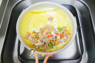 把刚才混合好的鸡肉蔬菜饭放到鸡蛋皮上