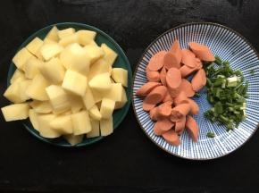 准备好所需材料，将土豆削去外皮，清洗干净后切成小块，火腿肠去掉包装，切成土豆丁差不多大小，最后将香葱洗净切碎；