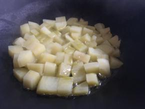 热锅倒入适量食用油，油热后倒入土豆丁，中小火煎炒；