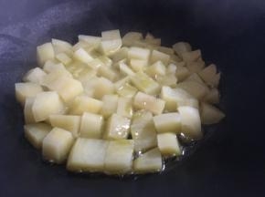 热锅倒入适量食用油，油热后倒入土豆丁，中小火煎炒；
