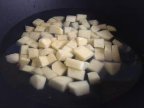 锅中倒入适量清水，煮沸倒入土豆丁，继续煮3分钟左右，煮至土豆丁透明后，捞出沥干水份；