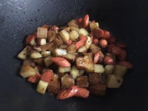 倒入土豆丁，翻拌均匀；