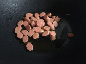 再次起锅，锅中留油底油后倒入火腿丁；