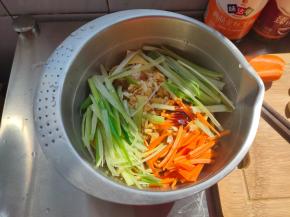 把沥水的豆腐皮放入小盆内，铺上蒜末、葱丝、胡萝卜丝，再淋上2勺生抽跟1勺蚝油。