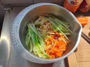 把沥水的豆腐皮放入小盆内，铺上蒜末、葱丝、胡萝卜丝，再淋上2勺生抽跟1勺蚝油。