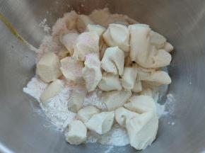 主面团黄油以外的材料放入厨师机面桶内，发酵好的种面剪成小块也一并放入，厨师机2档搅打十分钟左右，可揉成光滑的面团且略有筋度。
