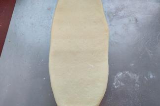 取一个松弛好的面团，轻轻的擀成长舌状。