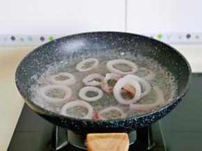 锅中加入水烧开，再下鱿鱼圈焯水，再次煮开捞出冷水冲洗干净备用。
