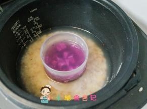 将蒸煮碗放在电饭锅跟大人的米饭一起煮，没有这个碗也可以用家里的不锈钢杯子替代