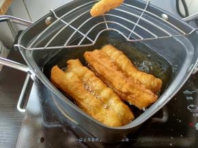 下锅前可以捏着两头，稍微抻长一些，将面团从中间先入油锅，再松开两头，油条下锅后前3秒不要动它，看见油条开始膨胀了，就可以拿筷子轻轻地拨弄，让油条两面都均匀受热，等油条在锅里颜色变得金黄，就可以捞出来沥油了。