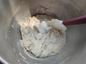 然后加入室温软化好的椰子油，并且把桶壁挂干净，再次启动厨师机搅拌均匀。