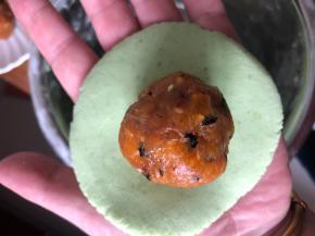 取一个揉匀后的小面团，大概45g左右，搓圆按扁，中间放一个蛋黄肉松馅。