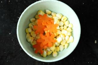 玉米粒和胡萝卜小花放入刚才煮西兰花的水内煮熟。