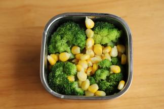 另一个便当里面铺上蛋黄饭，四周各放一个西兰花，放入玉米粒。