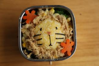 用海苔把蛋黄饭团做成小狮子的造型。