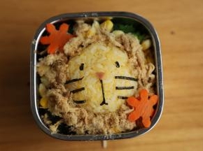 用海苔把蛋黄饭团做成小狮子的造型。