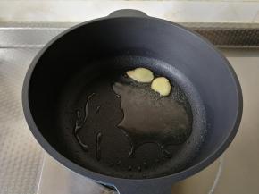 干净不粘锅中，用厨房纸巾擦干水。倒入玉米油，开大火，将玉米油烧热，下姜片爆香。