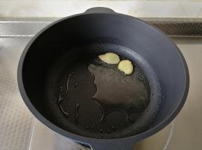 干净不粘锅中，用厨房纸巾擦干水。倒入玉米油，开大火，将玉米油烧热，下姜片爆香。