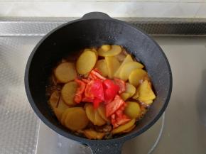 继续煮一会，煮到土豆用锅铲可以戳动。说明土豆已经很软糯了。加入红椒块，翻炒。