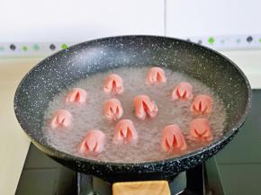 切好的香肠焯水，冷水下锅，大火煮开至香肠花瓣散开即可捞出。