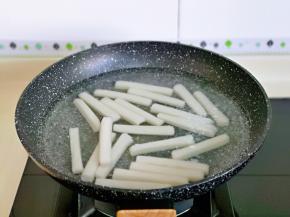 年糕焯水，冷水下锅，烧开后煮1分钟捞出过冷水。