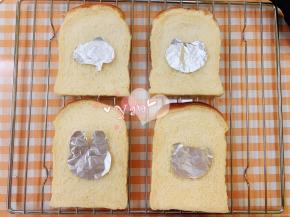 把卡通锡纸放在面包片上。