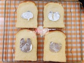 把卡通锡纸放在面包片上。