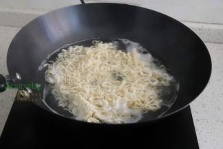 锅里倒入适量的水煮沸之后，放入面条，煮软之后，用筷子搅拌让面条松散，这样能快速煮熟。