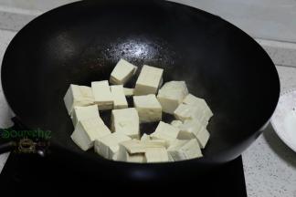 豆腐用冷水浸泡之后，切块，放入锅里煎至外皮焦黄。豆腐选择的是嫩豆腐，适合做大白菜炖豆腐，老豆腐适合煎和炸。