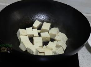 豆腐用冷水浸泡之后，切块，放入锅里煎至外皮焦黄。豆腐选择的是嫩豆腐，适合做大白菜炖豆腐，老豆腐适合煎和炸。